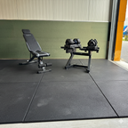 Complete WOLV Home Gym Setup in a garage: adjustable bench and dumbbell rack on black rubber flooring