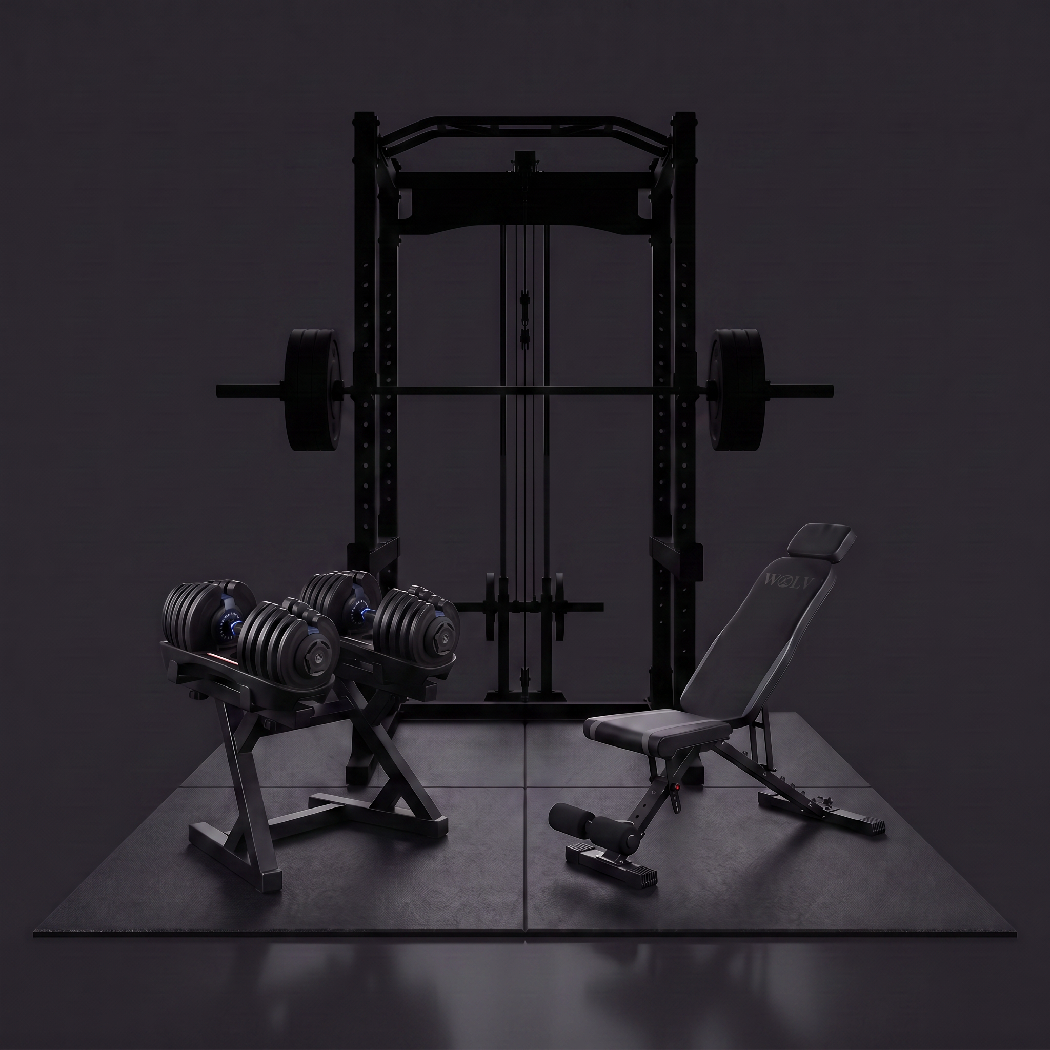 A dark gym equipment setup featuring a black cable pulley system power rack with a loaded barbell, a dual-dumbbell stand, and an adjustable weight bench on a dark mat against a black background.